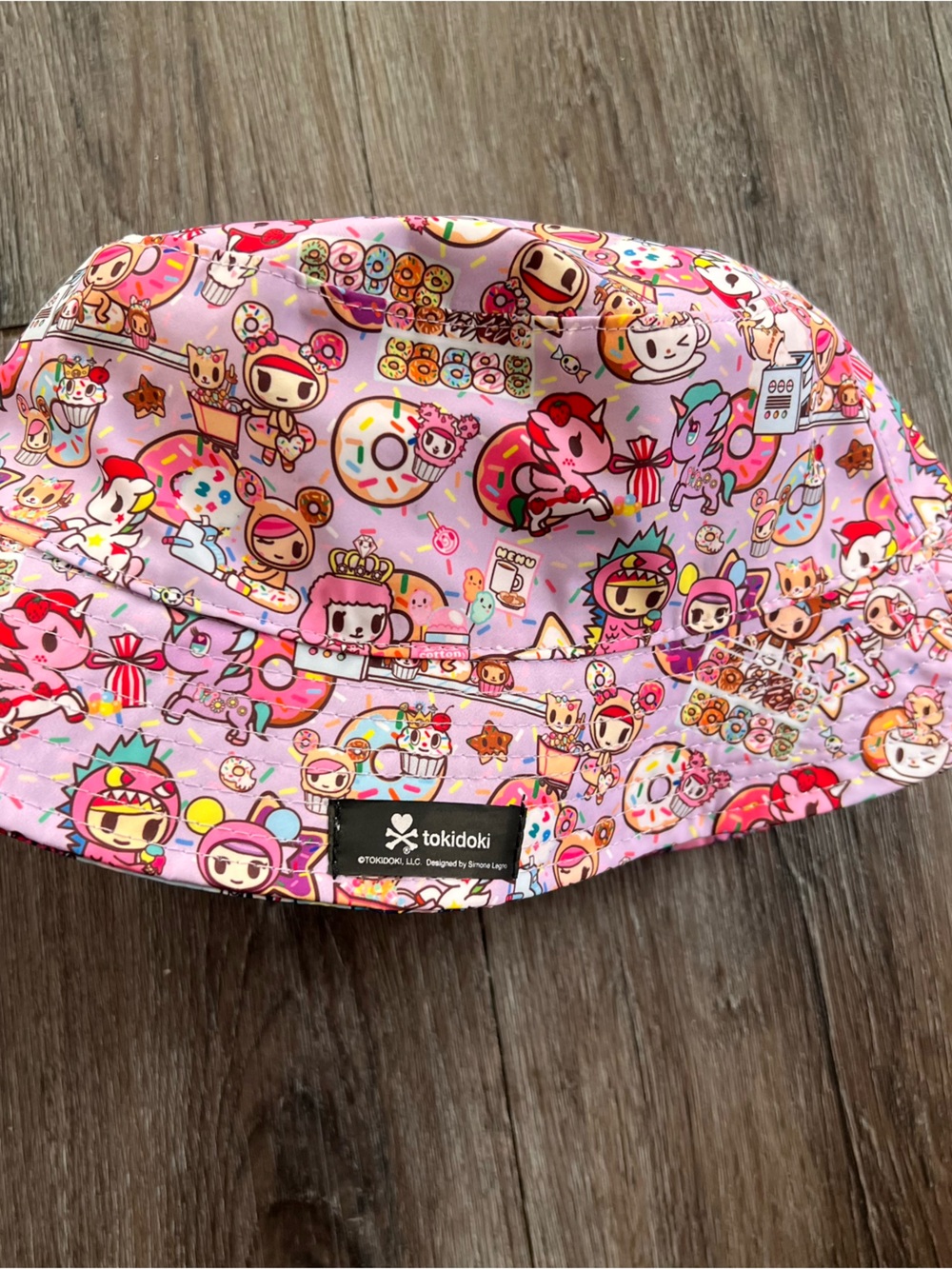 Reversible Tokidoki bucket hat features a vibrant "Donutella's Sweet Shop" print